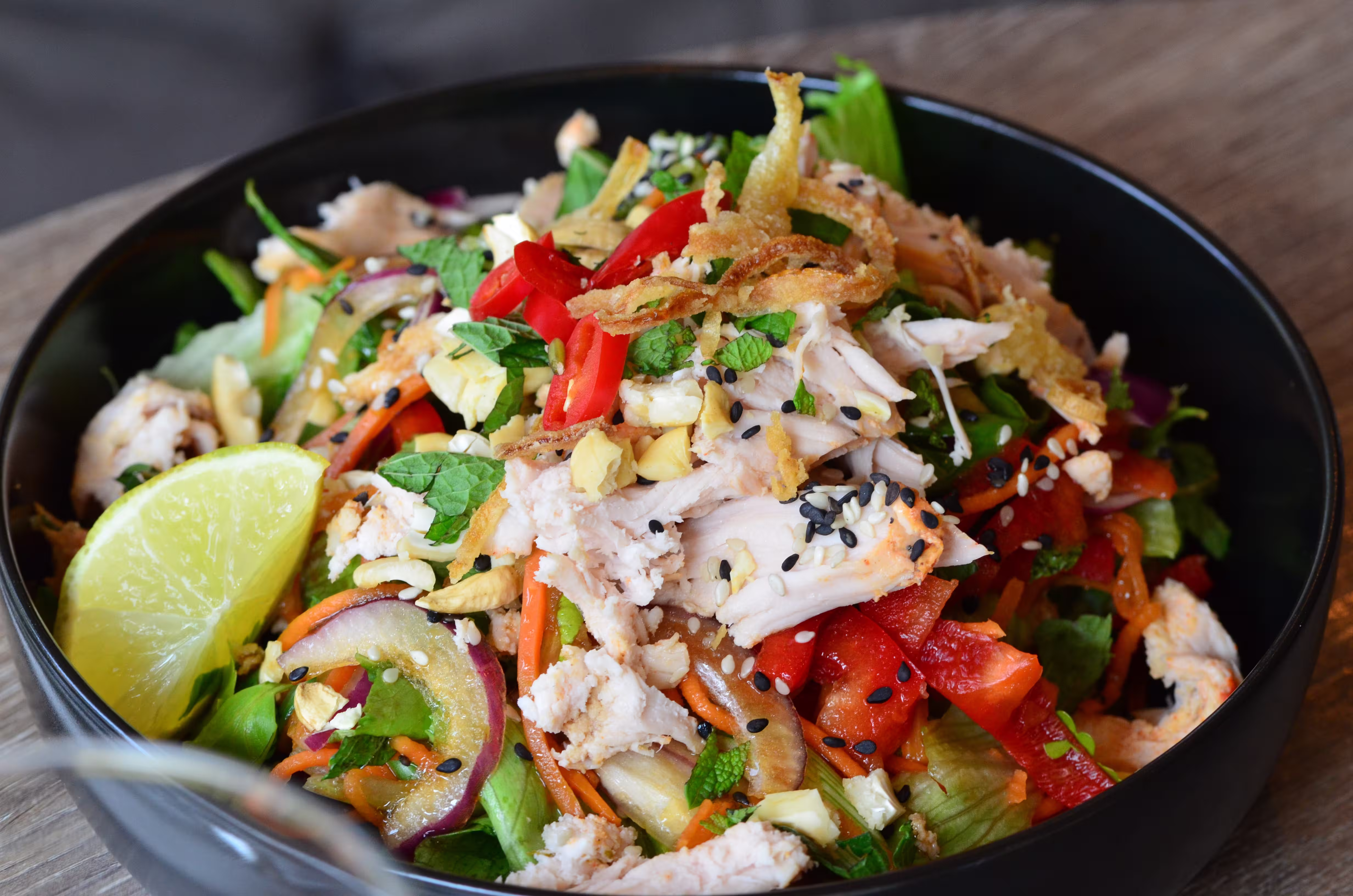 fresh green salad with crushed  Carom (Ajwain) seed in black bowl which help to support digestive system.